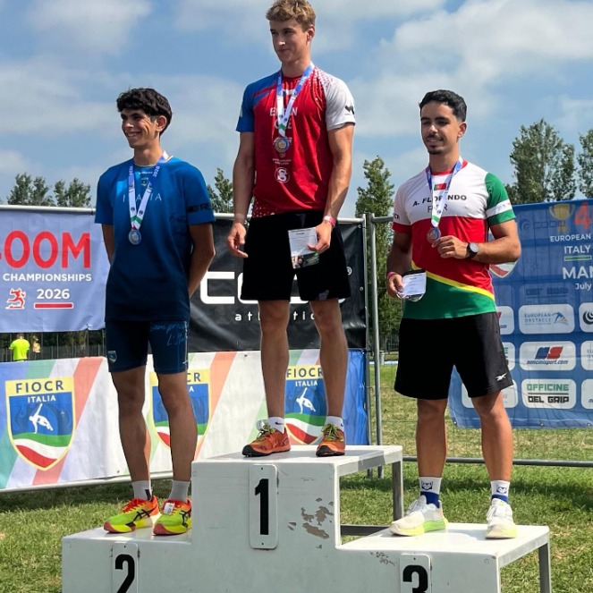Alex Florindo num pódio de corrida de obstáculos com a medalha